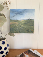 Load image into Gallery viewer, Still life acrylic painting with Santa gertrudis cattle, Australian Landscape by Leigh Suzie Art. Galah Press magazine in foreground.